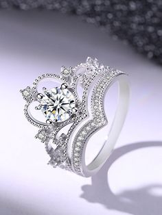 a white gold ring with a diamond center surrounded by small round brilliant cut diamonds on a shiny surface