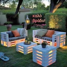 outdoor furniture made out of pallets in the grass with lights on them and some plants