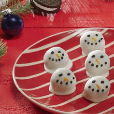 snowmen made out of marshmallows sitting on a red and white plate