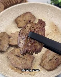 meat is being cooked in a white bowl