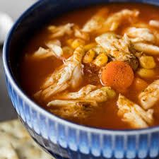 a blue bowl filled with soup and vegetables