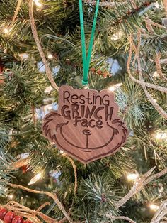 a wooden ornament hanging from a christmas tree with the words resting grin face on it