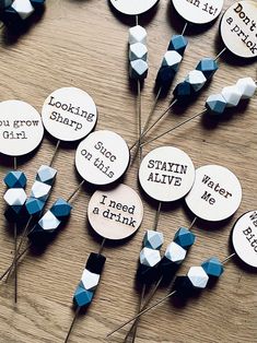 several pins with words on them sitting next to each other in front of a wooden table