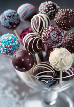 a glass bowl filled with chocolate covered cake pops