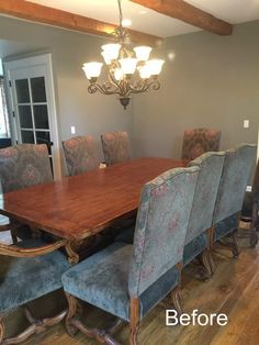 a dining room table with blue chairs and chandelier