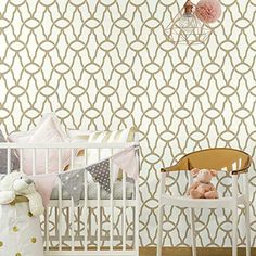 a baby crib in front of a white wall with gold circles and pink pom poms