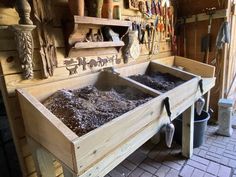 two wooden boxes filled with dirt in a room full of woodworking tools and other items