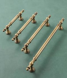 four antique style handles and knobs on a green surface