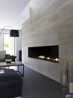 an image of a living room with a fire place on the wall and couches