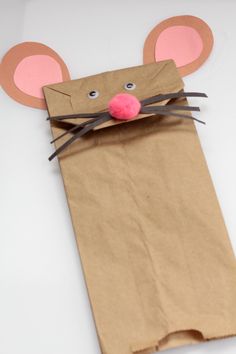 a brown paper bag with a mouse on it's side and pink nose sticking out