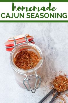 homemade cajun seasoning in a glass jar with spoons on the side and text overlay that reads homemade cajun seasoning