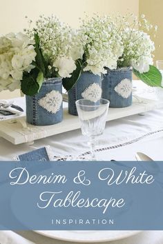 the table is set with white flowers and blue vases