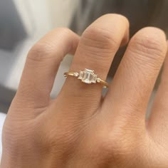 a woman's hand with a diamond ring on it