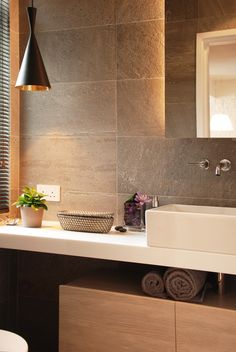 a bathroom with a sink, mirror and toilet in it's corner next to a window