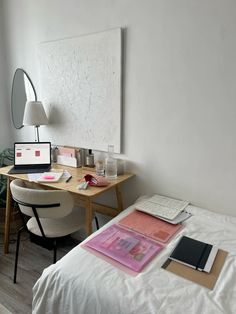 a bedroom with a bed, desk and chair next to a large painting on the wall