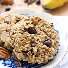 two oatmeal breakfast cookies on a blue and white plate with pecans