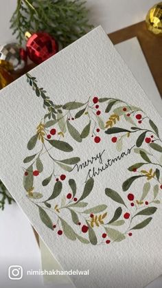 a christmas card with the words merry christmas written on it, surrounded by evergreen branches and red berries