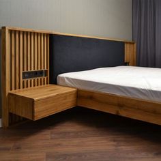 a bed with a wooden headboard and night stand next to a curtained window