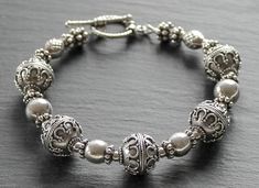 "Bold and glamorous sterling silver bracelet with beautifully textured sterling silver beads that measure approximately 12\" in diameter, and complementary toggle clasp.  This elegant bracelet is sure to enhance any look.  Size:  will fit 6 1/2\" - 7\" wrist." Elegant Sterling Silver Bracelet With Spacer Beads, Elegant Bracelets With Toggle Clasp And Round Beads, Handmade Silver Beaded Bracelets For Formal Occasions, Silver Handmade Beaded Bracelets For Formal Occasions, Elegant Sterling Silver Bracelet With Polished Beads, Elegant Round Sterling Silver Bracelet With Toggle Clasp, Elegant Antique Silver Sterling Bracelet, Elegant Antique Sterling Silver Bracelet, Elegant Adjustable Sterling Silver Bracelet With Spacer Beads