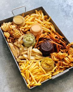 a tray filled with french fries and dipping sauces