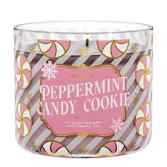 a pink and white candle that says peppermint candy cookie