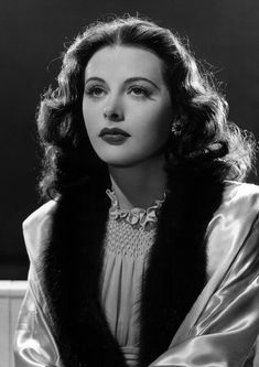 an old black and white photo of a woman wearing a fur stole over her shoulders