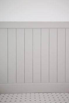 an empty room with white paneling on the wall