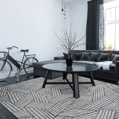 a living room filled with furniture and a bicycle parked next to it on the wall