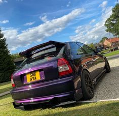 a purple car parked on the side of a road