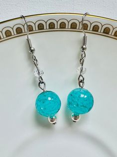 pair of blue glass beaded earrings on white plate