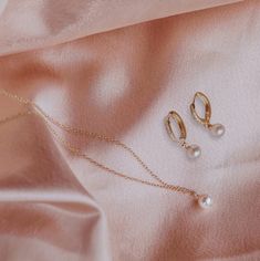 This exquisite handcrafted pearl necklace and huggie hoops gift set are a timeless fusion of elegance and style.  The necklace features a lustrous pearl delicately hanging on a chain, creating a classic yet modern look. Paired with my sleek Huggie diamond cz hoops adorned with subtle detailing, this set is the perfect balance of sophistication and versatility.  Elevate any outfit with this thoughtful and beautifully crafted ensemble, making it an ideal gift for those who appreciate the finer thi Delicate Pearl Charm Jewelry Gift For Her, Elegant Hypoallergenic Round Pendant Jewelry, Feminine Round Jewelry With Pearl Charm, Minimalist Hoop Pearl Charm Jewelry, Minimalist Hoop Jewelry With Pearl Charm, Feminine Round Pearl Charm Jewelry, Feminine Pearl Charm Jewelry, Delicate Pearl Jewelry As A Gift For Her, Elegant Jewelry Sets With Pearl Pendant For Gift