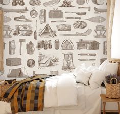 a bed room with a neatly made bed and a wallpaper covered in camping related items