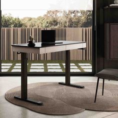 a modern desk in the middle of a room with a large sliding glass door leading outside