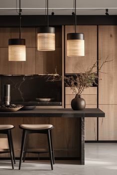 a table with two stools and some lights hanging from it's ceiling in a kitchen