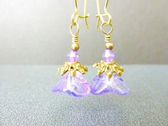 Lavender Earrings Purple Earrings Flower Earrings, Handmade Jewelry, Vintage Style, Czech Bell Flower EarringsDeep lavender purple czech glass bell flower earrings are encircled by brass filigree bead caps, topped with lavender purple crystal bicones and hung on brass kidney hooks. These lavender flower earrings remind me of looking up from under the ocean, if the ocean were purple :-). I do have other lovely czech glass bell flower earrings in different rainbow shimmer colors, as shown in the l Lavender Earrings, Emerald Bracelet, Earrings Purple, Purple Earrings, Earrings Flower, Purple Crystal, Blue Gift, Emerald Earrings, Lavender Purple