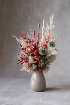 a vase filled with lots of different types of flowers