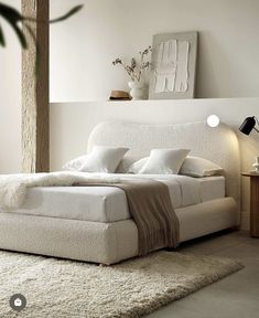 a white bed sitting in a bedroom on top of a rug