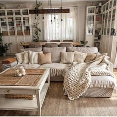 a living room filled with lots of furniture and pillows on top of a wooden floor