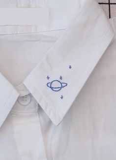 a white dress shirt with an embroidered space motif