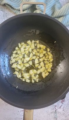 a frying pan filled with food sitting on top of a stove next to a towel