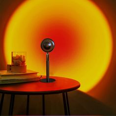 a table with a book and a cell phone on it, in front of a yellow sun