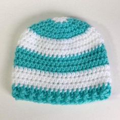 a crocheted blue and white beanie on a table with the top half turned down