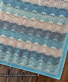 a blue and white crocheted blanket sitting on top of a wooden table