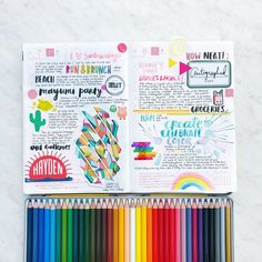 an open planner book with colored pencils and crayons on the pages next to it