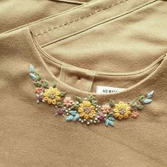 a close up of a shirt with flowers on the front and back of it's collar