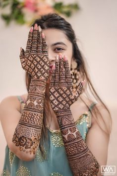 a woman with her hands covered in henna