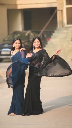 two women dressed in black posing for the camera