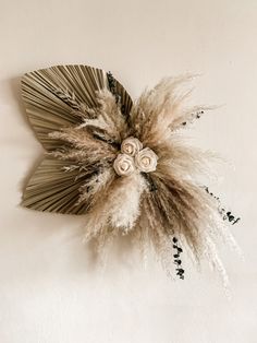 a dried flower on a white wall with black and silver accents, in the shape of a fan