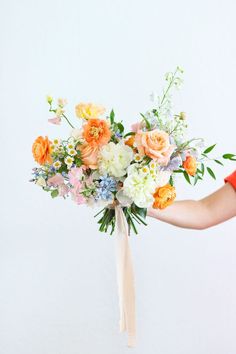 a woman holding a bouquet of flowers in her hand