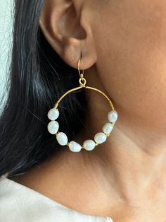 Complement your personality and style with this gorgeous pair of earrings handcrafted by our local Indian artisans in brass, natural stones, and gold plating. Weight: 16 grams per pair. The drop length of the hoops is 6 cm.  The diameter of the hoops is 5 cm. Premium Quality. Gold Brass Hoop Earrings With Pearl Drop, Gold Hoop Earrings With Pearl Drop In Brass, Brass Round Jewelry With Pearl Drop, Round Pearl Drop Brass Jewelry, Round Brass Jewelry With Pearl Drop, Gold Hoop Pearl Earrings Nickel Free, Handmade Hoop Pearl Earrings, Artisan Brass Hoop Earrings Wire Wrapped, Handmade Gold-plated Round Pearl Earrings